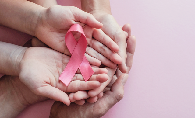 Mains liés avec ruban rose pour remercier les partenaires de s'être mobilisés contre le cancer du sein